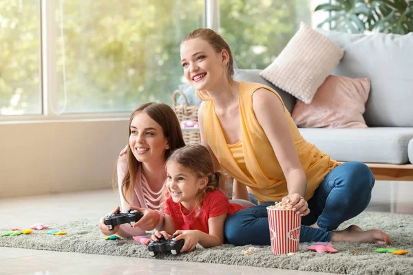 Happy lesbian couple with little daughter playing video game at home — Stock Photo, Image