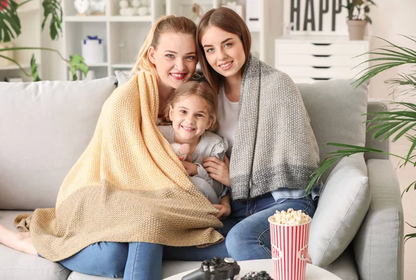 Happy lesbian couple with little daughter at home — Stock Photo, Image