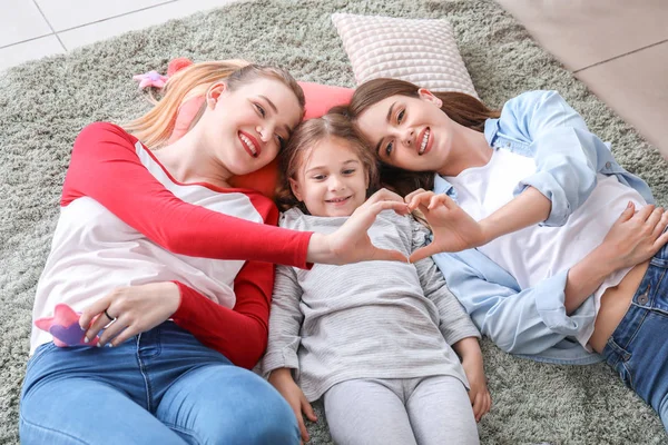 Happy lesbian couple with little daughter at home — Stock Photo, Image