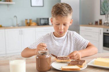 Mutfakta yayılan çikolata ile lezzetli tost yeme komik küçük çocuk