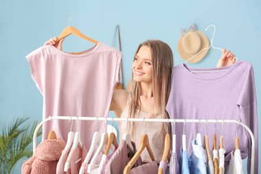 Soyunma odasında kıyafet seçen genç kadın