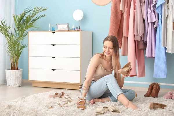 Young woman choosing shoes in dressing room — Stock Photo, Image
