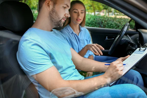 Autista e agente di assicurazione firma contratto mentre seduto in auto — Foto Stock