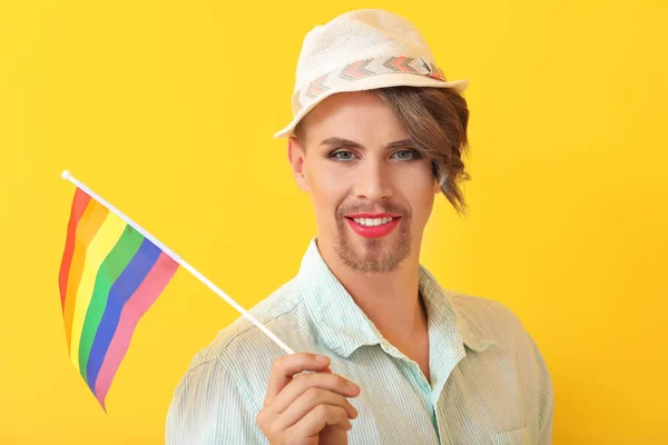 Portret van jonge transgender vrouw met gay vlag op kleur achtergrond — Stockfoto