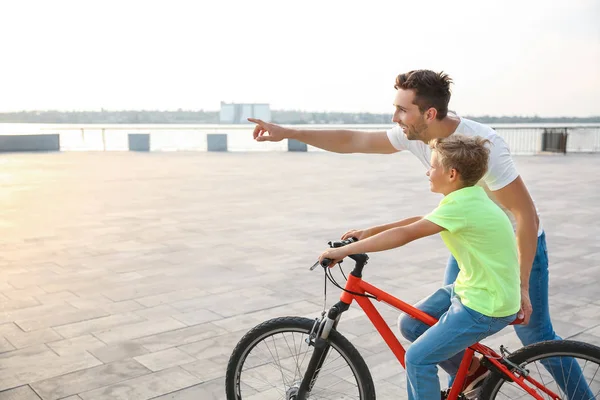 父は息子に屋外で自転車に乗るように教える — ストック写真