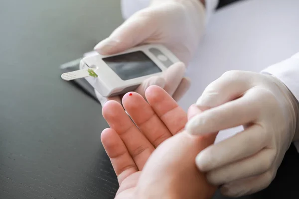 Médico que verifica o nível de açúcar no sangue do paciente diabético na clínica, close-up — Fotografia de Stock