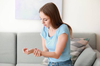 Genç kadın evde Bilek ağrısı muzdarip