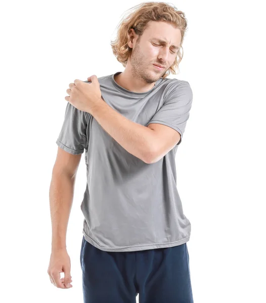 Young man suffering from pain in shoulder on white background — Stock Photo, Image