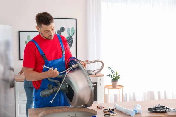 Klempner installiert Spüle in Küche — Stockfoto