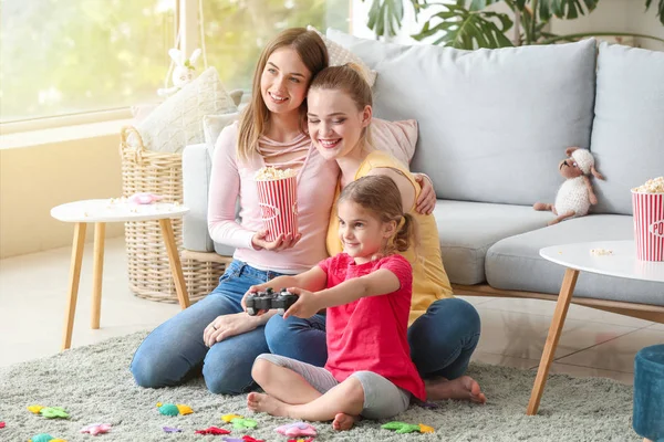 自宅でビデオゲームをプレイする小さな娘と幸せなレズビアンのカップル — ストック写真