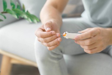 Şeker hastası evde kan şekeri seviyesini ölçüyor, yakın plan.