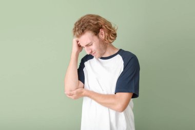 Genç adam renk arka planda dirsek ağrısı muzdarip