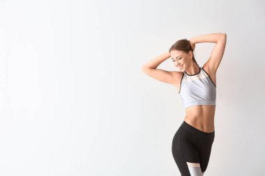 Işıklı arka planda güzel, sportif bir kadın. Kilo verme konsepti