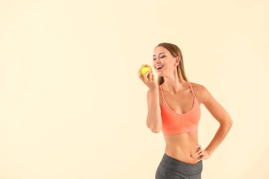 Renkli arkaplanda elma olan güzel, sportif bir kadın. Kilo verme konsepti