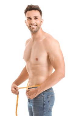 Beyaz arka planda ölçüm bandı olan yakışıklı kaslı bir adam. Kilo kaybı kavramı