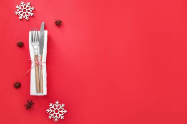 Peçeteli temiz çatal bıçak seti ve arka planda Noel dekoru