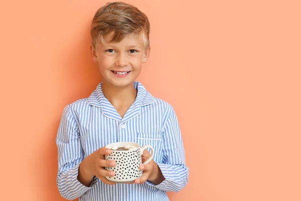 Χαριτωμένο μικρό αγόρι πίνοντας ζεστή σοκολάτα στο φόντο χρώμα — Φωτογραφία Αρχείου