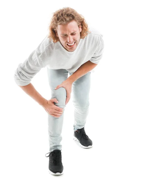 Genç adam beyaz zemin üzerinde diz ağrısı muzdarip — Stok fotoğraf