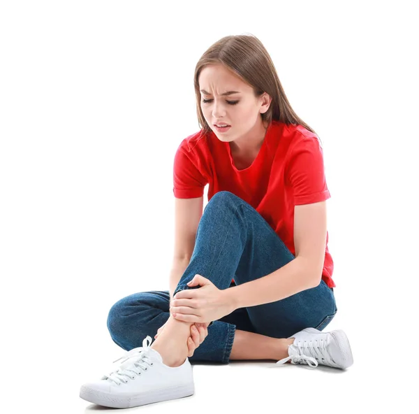 Young woman suffering from pain in leg on white background — Stock Photo, Image