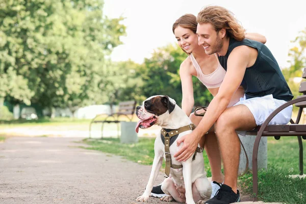 Deportiva joven pareja con lindo perro en parque — Foto de Stock
