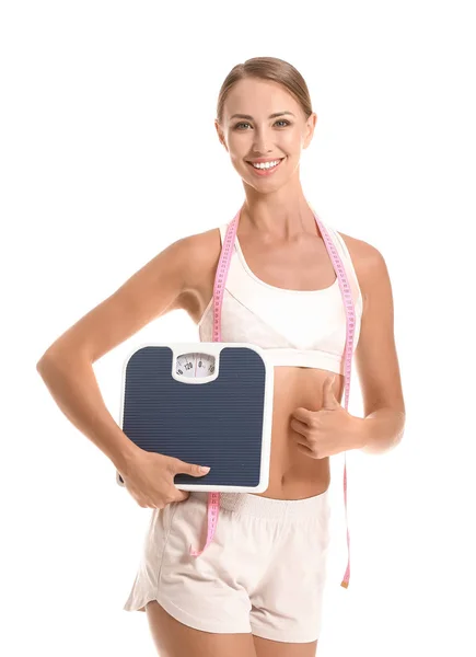 Beautiful young woman with measuring tape and scales showing thumb-up on white background. Weight loss concept — Stock Photo, Image