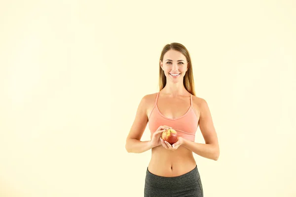Schöne sportliche Frau mit Apfel auf farbigem Hintergrund. Gewichtsverlust-Konzept — Stockfoto