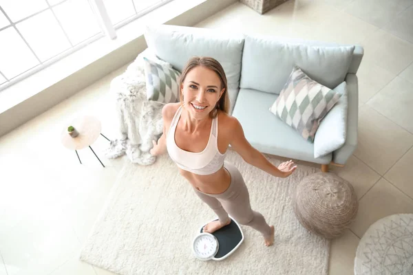 Boldog fiatal nő a mérleg otthon. Testsúlycsökkenés koncepció — Stock Fotó