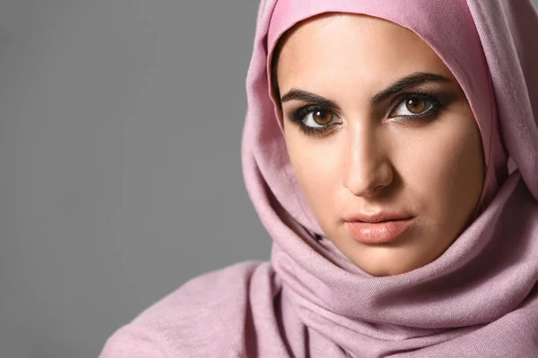 Portret van mooie moslim vrouw op grijze achtergrond — Stockfoto