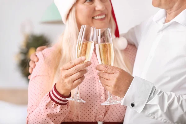 Pareja madura con copas de champán celebrando la Navidad en casa — Foto de Stock