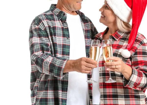 Noel Baba şapkalı mutlu çift ve beyaz arka planda şampanya kadehleri.