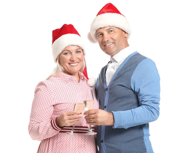 Portrait of happy mature couple in Santa Claus hats and with glasses of champagne on white background — Stock Photo, Image