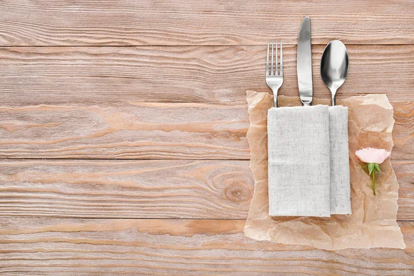 Sauberes Besteck mit Serviette auf Holzgrund — Stockfoto