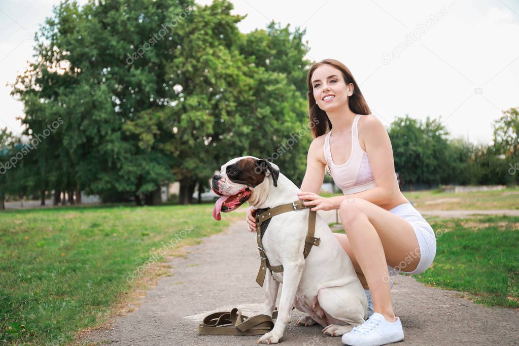 Sporty young woman with cute dog in park