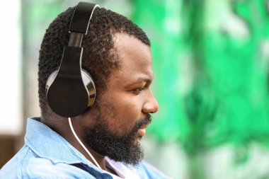 Yakışıklı Afro-Amerikan adam açık havada müzik dinliyor