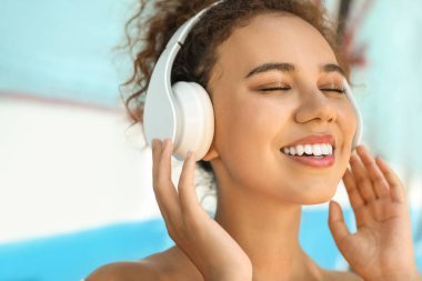 Güzel Afrikalı-Amerikalı kadın açık havada müzik dinliyor