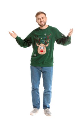 Beyaz arka planda Noel süveteri giyen genç adam.