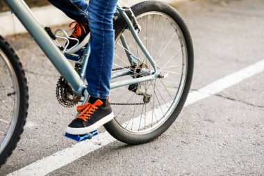 Dışarıda bisiklet süren küçük bir çocuk.