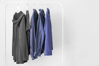 Hafif arka planda şık giysiler ile Rack