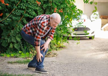 Dışarıda bacağı ağrıyan son sınıf öğrencisi.