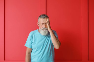 Kıdemli adam renk arka planda baş ağrısı muzdarip