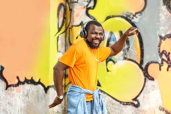 Jóképű afro-amerikai férfi zenét hallgat és táncol a szabadban — Stock Fotó