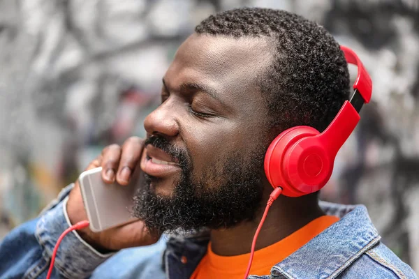 英俊的非洲裔美国男子在户外听音乐 — 图库照片