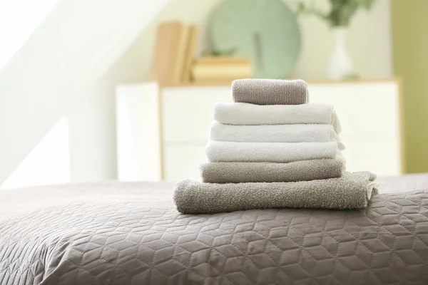 Stack of clean towels on bed — Stock Photo, Image