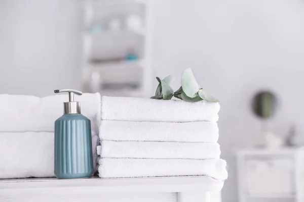 Soft clean towels with soap on table in bathroom — Stock Photo, Image