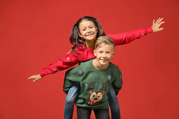 Söta barn i jul tröjor på färg bakgrund — Stockfoto