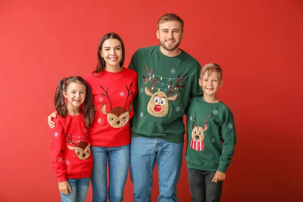 Happy family in Christmas sweaters on color background — Stock Photo, Image