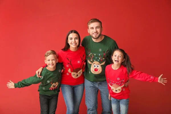 Happy family in Christmas sweaters on color background — Stock Photo, Image