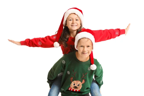 Маленькі діти в різдвяних светрах і капелюхах Санти на білому тлі — стокове фото