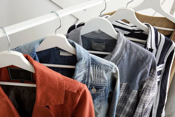 Rack com roupas penduradas dentro de casa, close-up — Fotografia de Stock