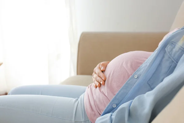 Beautiful pregnant woman sitting on sofa at home — Stock Photo, Image